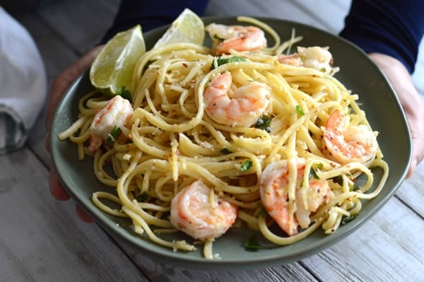 A pot with easy shrimp scampi linguine without wine with tongues in the pot and a puddle of sauce.