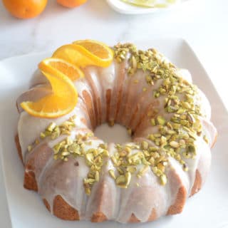 An orange cake on a plate with orange on top