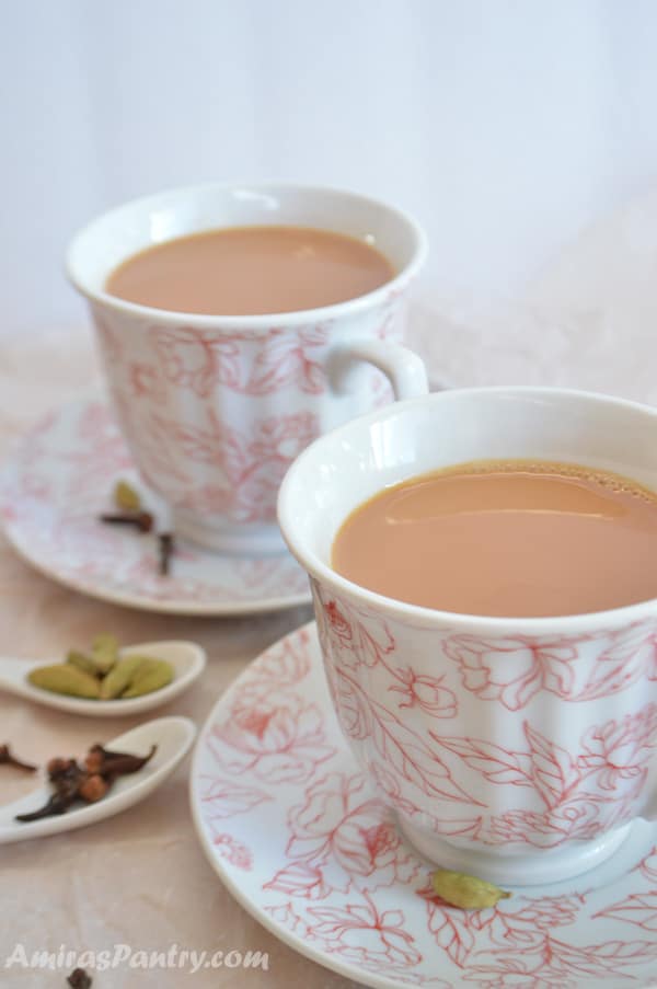 Two cups of spiced tea on plates