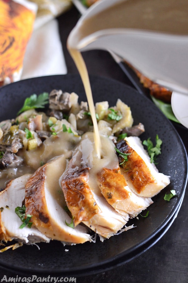 Pouring gravy on slices of perfect moist turkey.