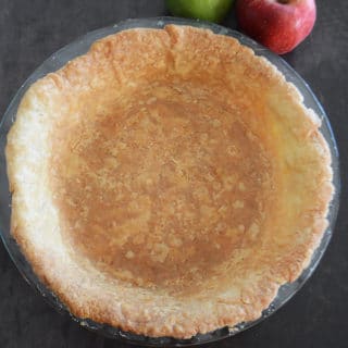 An apple sitting on top of a table, and a close up of food, with Pie crust