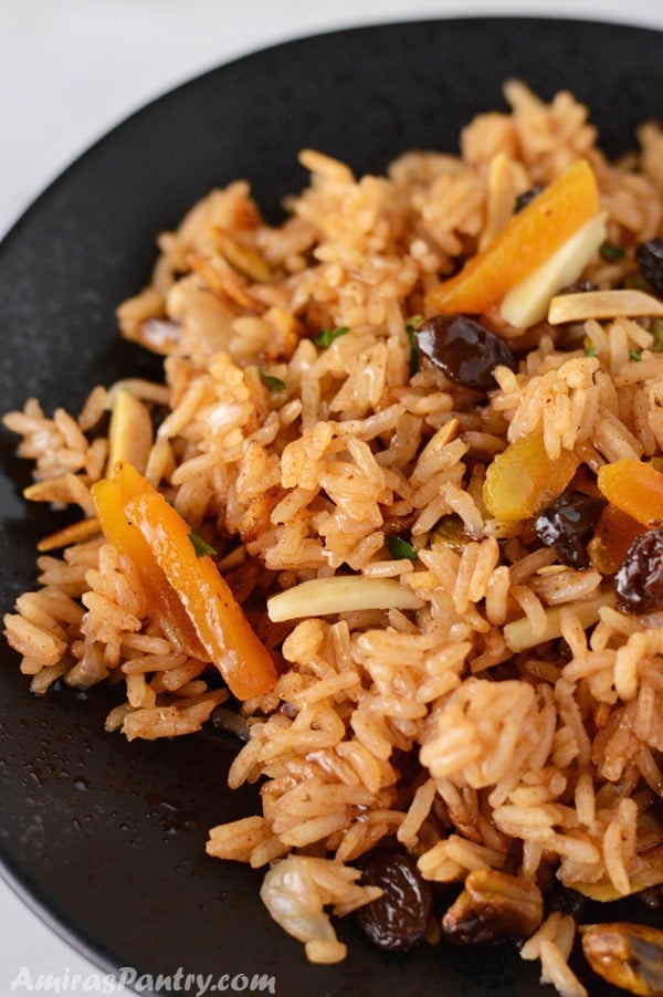 A close up on a plate of food, with Pilaf Rice and nuts
