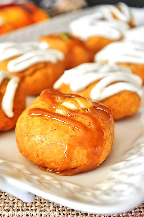 A white serving plate with sweet potato cookies topped with caramel sauce.
