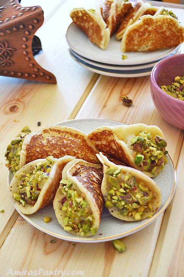 A plate of food on a table, with Qatayef and nuts