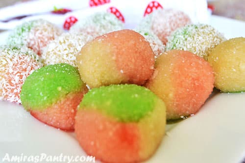 A close up of a plate with colored dessert balls