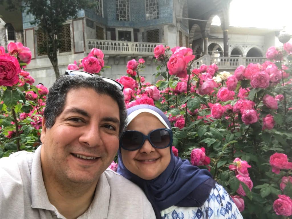 Amira and her husband standing in front of a building