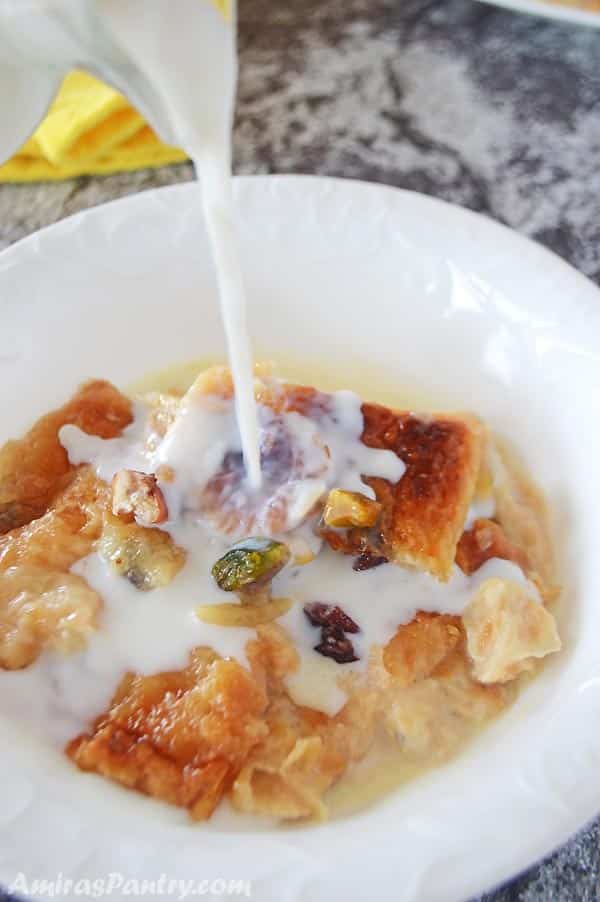 A close up of food on a plate, with Bread Pudding and milk