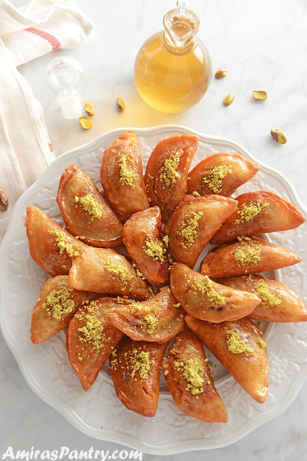 A white dish with assorted folded pancakes with nutes