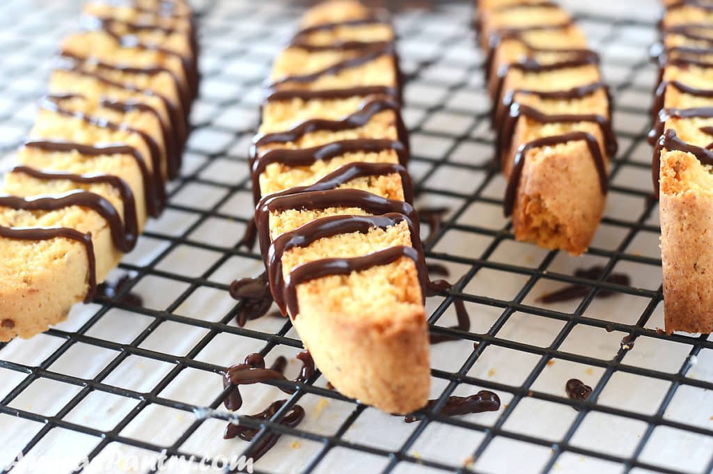 biscotti cookies placed on a cooling rack and decorated with chocolate ribbons.