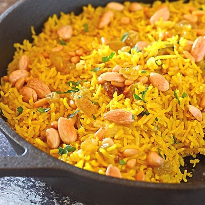 A pan of yellow rice with nuts