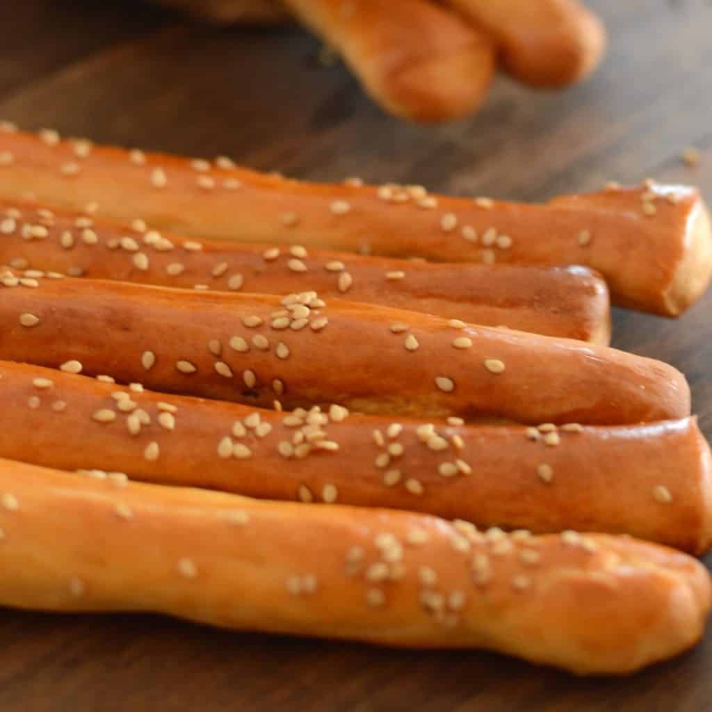 breadsticks lined on a wooden table