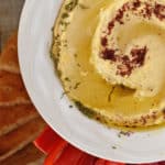 A white bowl filled with creamy hummus