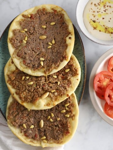 A plate of food on a table, with Sfiha