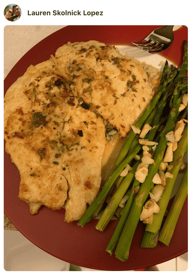 A plate of food with chicken francese and asparagus made by a fan