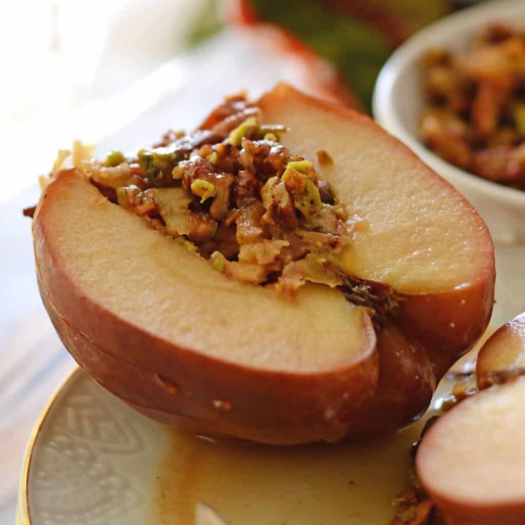 stuffed apples with nuts placed on a white plate.