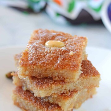 basboosa squares stacked on top of each other on a white plate