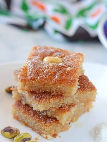 basboosa squares stacked on top of each other on a white plate