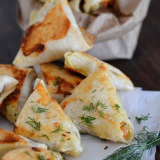 baked samosas on placed on parchment paper on a wooden table
