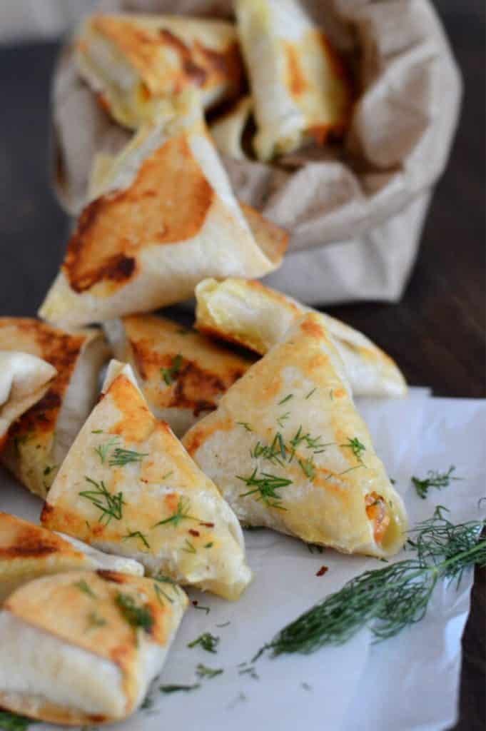 baked samosas on  placed on parchment paper on a wooden table