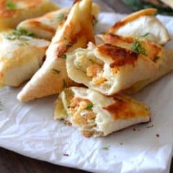 samosas on a parchment paper and cut open to show creamy dill shrimp filling