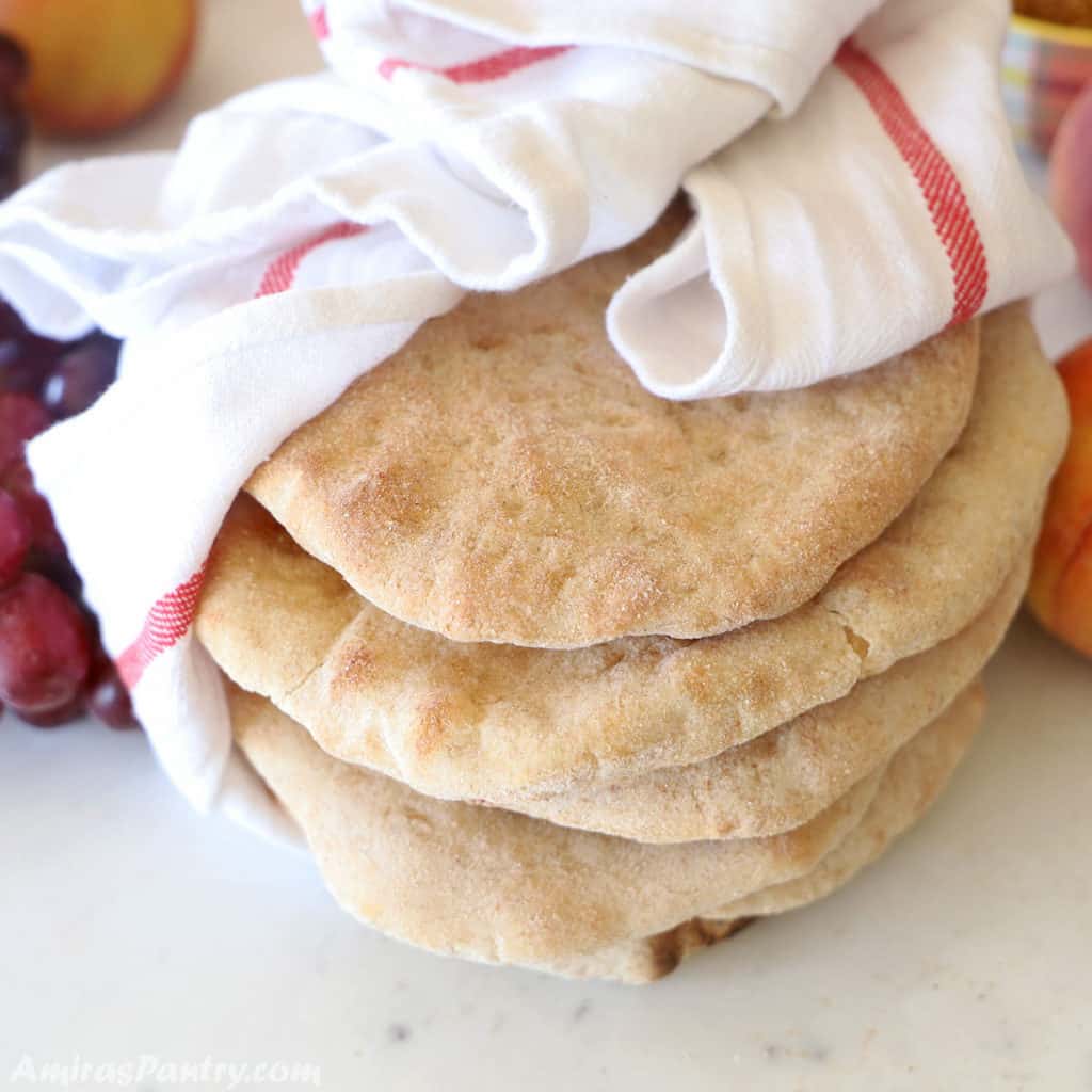 taboon loaves wrapped in a white kitchen cloth on a marbled table