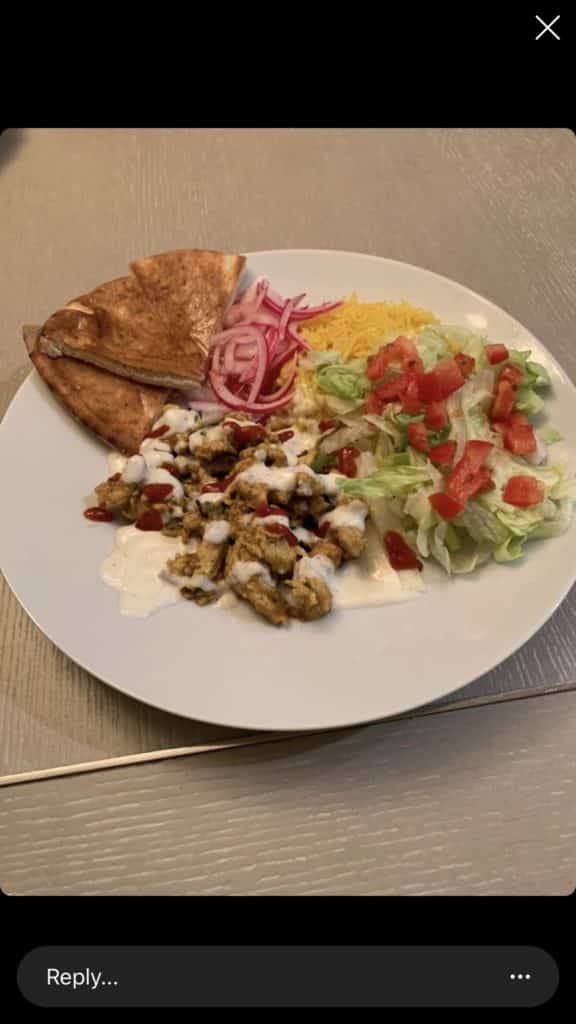 A plate of chicken shawarma on a table by a fan