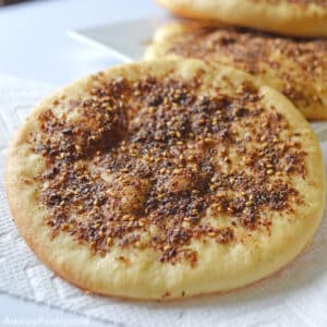 Manakeesh with za'atar made with the dough and placed on a white kitchen towl