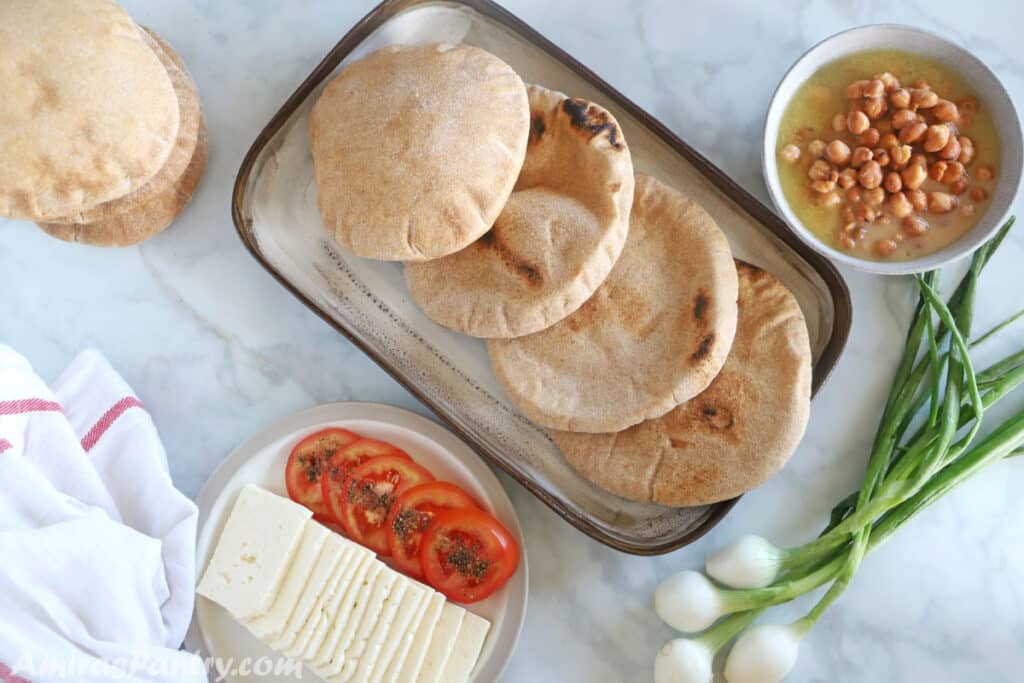 Egyptian food breakfast table with whole wheat pita, ful and white cheese.