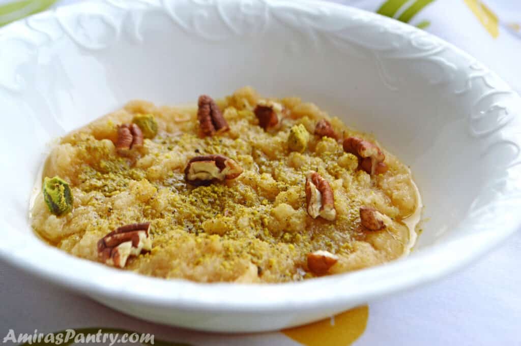 halwa in a white bowl decorated with crushed nuts