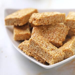 A stack of sesame cany bars arranged on a white plate.