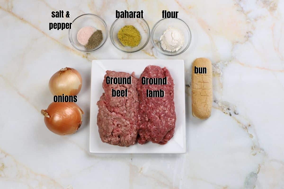 Ingredients for kofta kebabs on a white marbled surface.