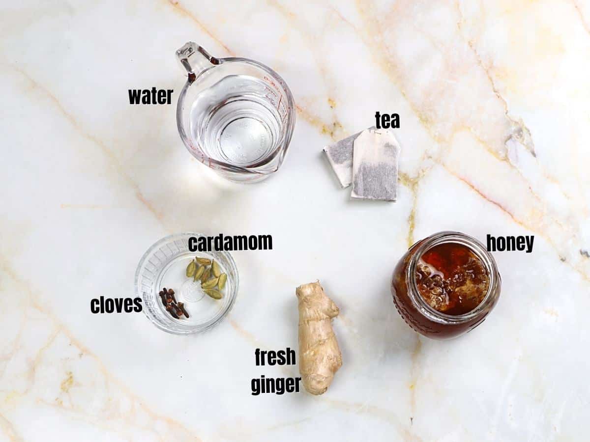 Cardamom tea ingredients on a marble surface.