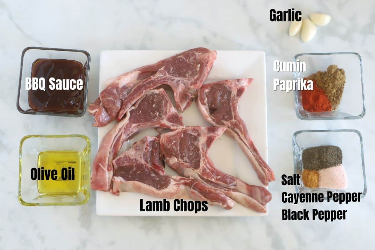Ingredients of lamb chops placed on a white marble counter top.