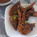 Lamb chops cut into pieces and placed on a white plate.