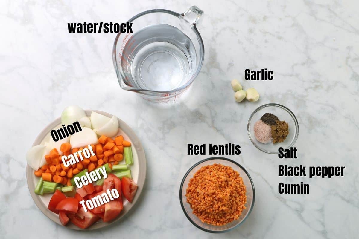 Red lentil soup ingredients on a white marble table.