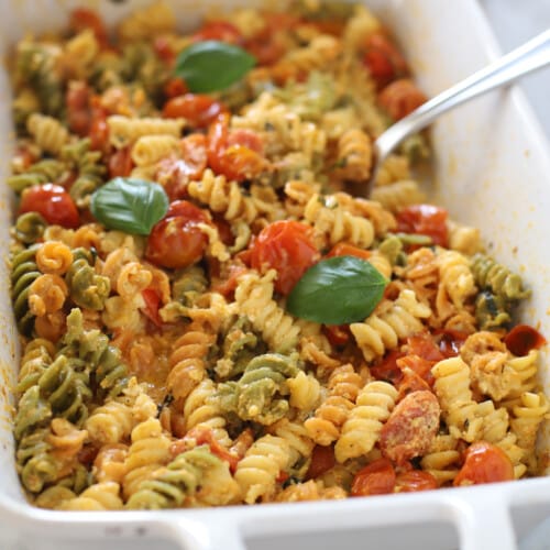 Feta pasta in a white casserole dish with a spoon in it.
