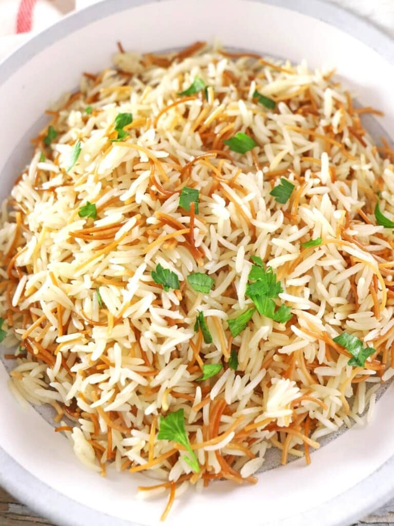 A big bowl of Lebanese rice garnished with parsley.