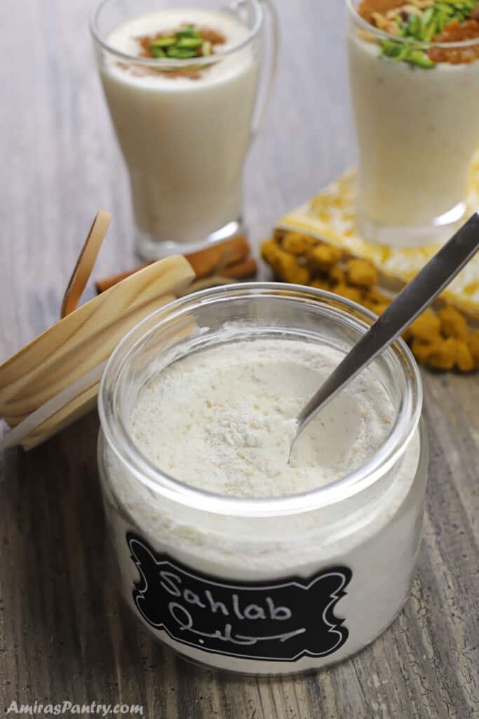 A jar of Sahlab powder mix with a spoon in it.
