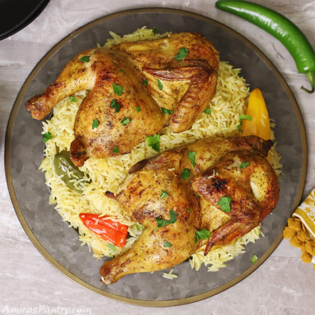 A big serving platter of mandi garnished with chopped parsley.