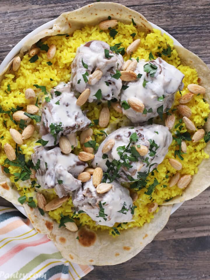 Mansaf platter placed on a wooden table.