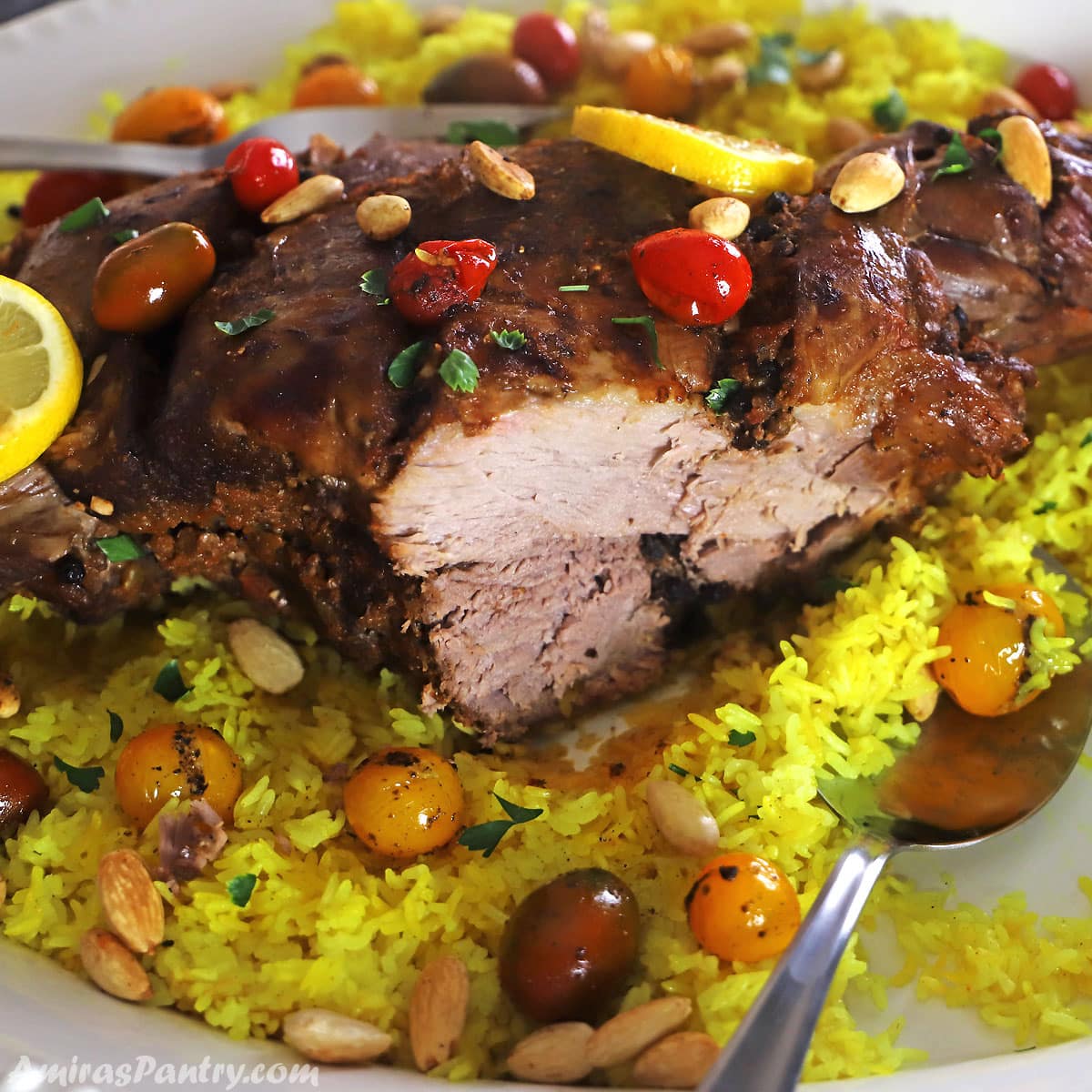 A close look at a leg of lamb with a piece carved out on a yellow rice platter.
