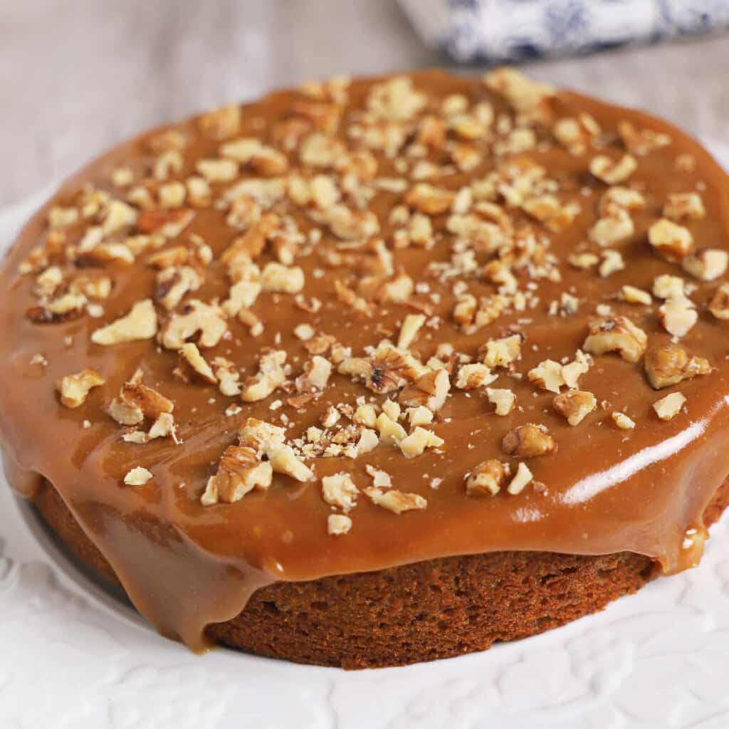 A close up look at date cake placed on a white serving platter.