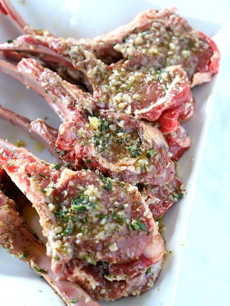marinated lamb chops on a white plate.