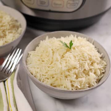 A grey bowl of basmati rice with the instant pot in the back.