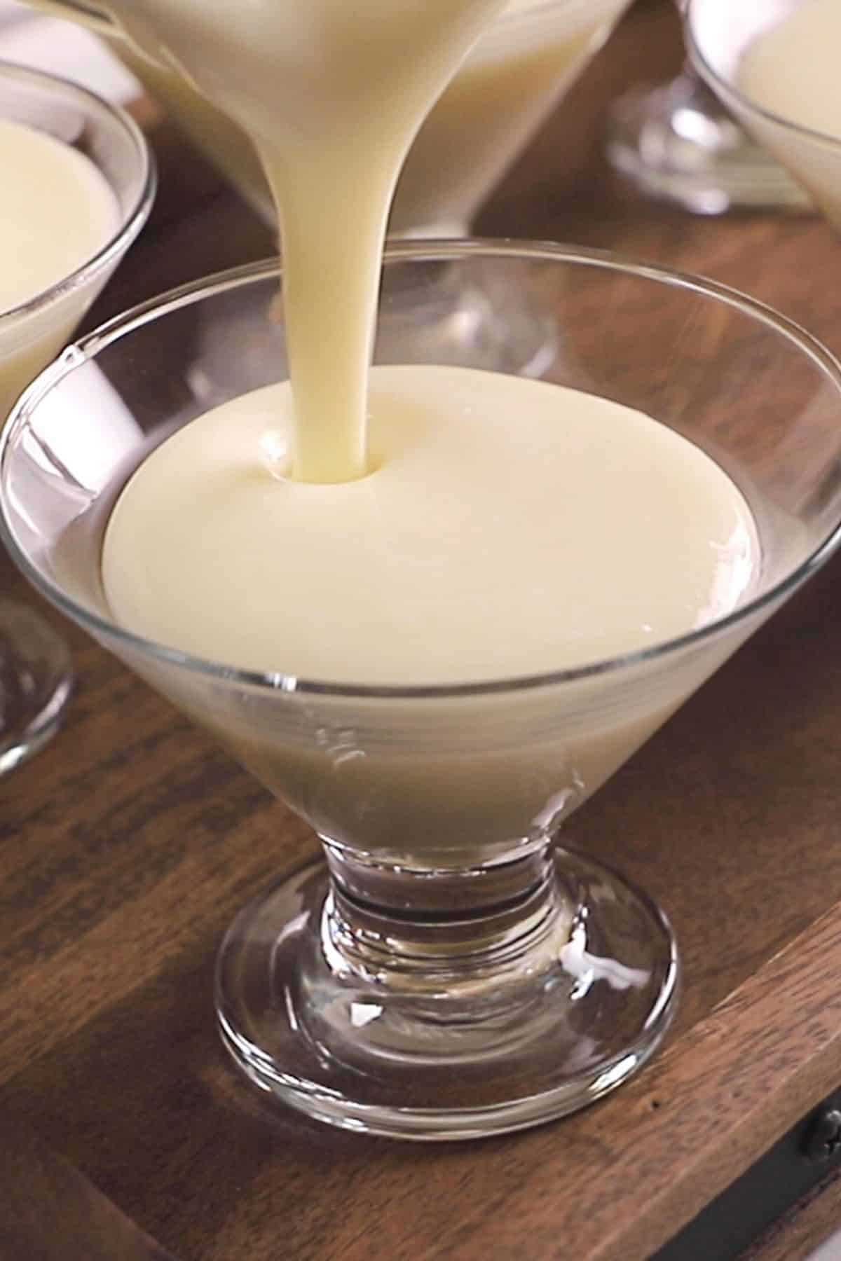 Pouring hot Middle Eastern milk pudding into serving cups.