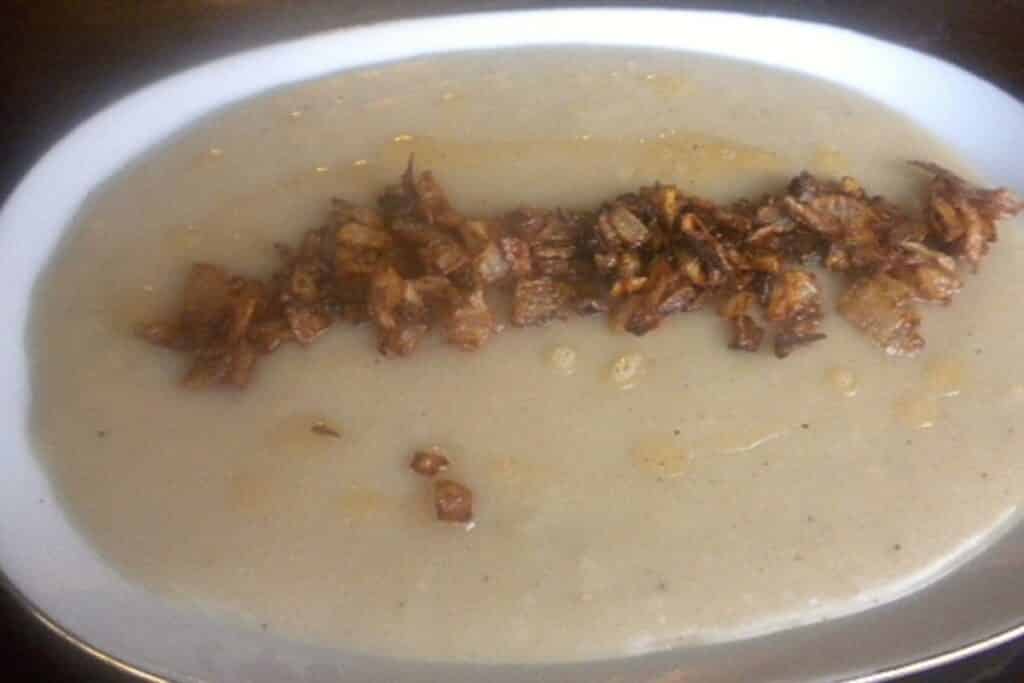 A plate with kishk and garnished with fried onions.