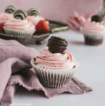 A strawberry chocolate cupcakes on a pink towel.