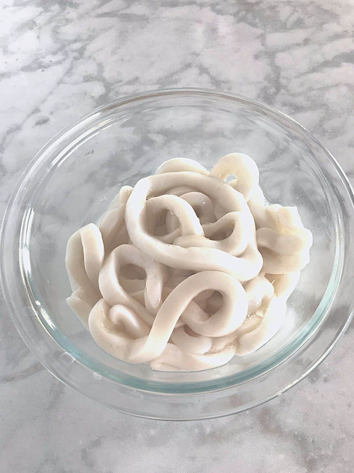 A bowl of sruid rings soaking in vinegar.