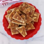 Top view of almond brittle in a red dish.