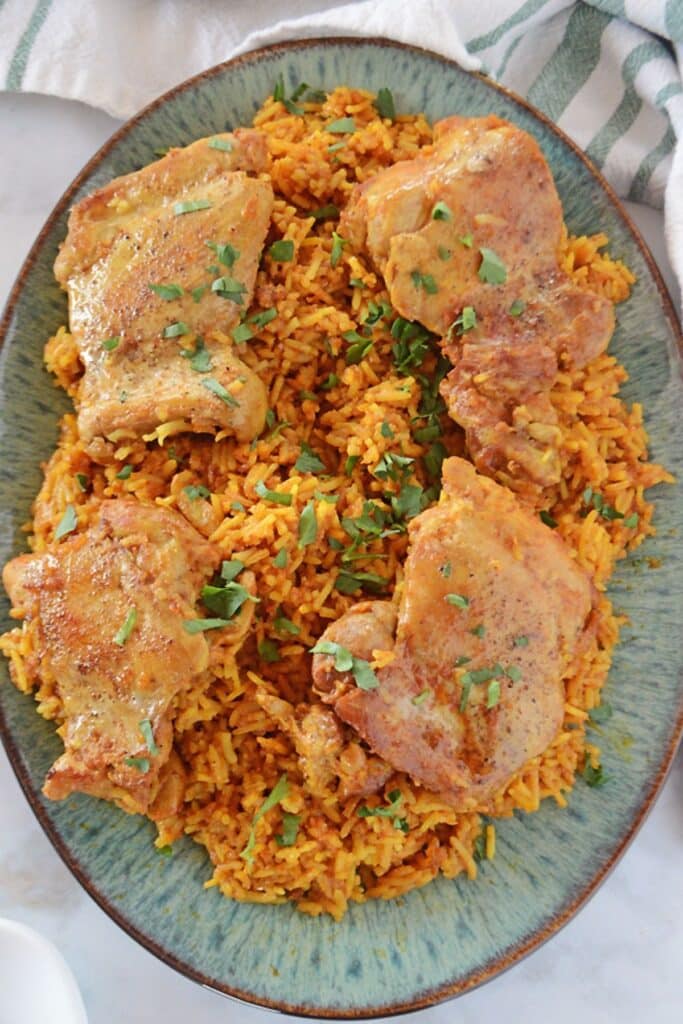 A top view of kabsa dish garnished with chopped parsley.